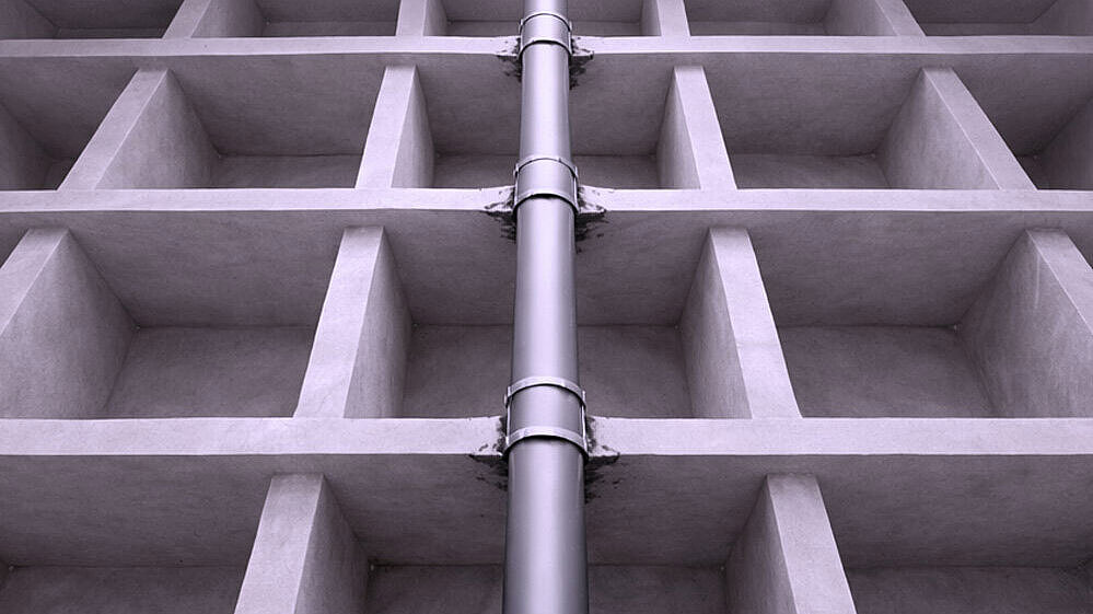 Schematische weergave van een buis die door meerdere vloeren naar boven loopt.